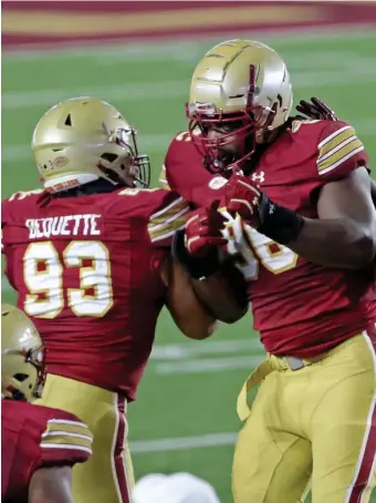  ?? STuART cAHiLL / HeRALd sTAff; BeLOw, geTTy imAges fiLe ?? MORE FILM: Boston College defensive tackle Chibueze Onwuka celebrates his fumble recovery with fellow defensive tackle Luc Bequette on Saturday against Louisville. Both players are graduate transfers and could benefit from an additional year of eligibilit­y granted by the NCAA. Below, BC middle linebacker Max Richardson runs through a tunnel of his teammates to celebrate senior night before the game against Louisville.