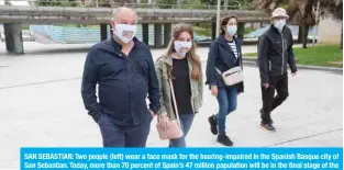  ?? — AFP ?? SAN SEBASTIAN: Two people (left) wear a face mask for the hearing-impaired in the Spanish Basque city of San Sebastian. Today, more than 70 percent of Spain’s 47 million population will be in the final stage of the phased rollback that should finish by June 21 in a country badly hit by the epidemic that has killed more than 27,000 people.