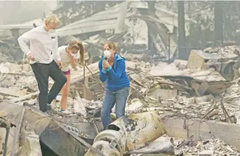  ??  ?? Mary Caughey, reacciona tras encontrar su anillo de bodas entre los escombros de su casa, destruida por un incendio, en la localidad de Kenwood, en California. Los bomberos luchan por combatir el fuego en la zona.