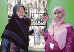  ??  ?? NORLIDA (kiri) bersama Reni Rahayou selepas pemasangan penapis air.