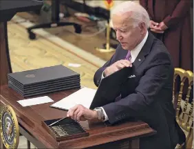 ?? Alex Wong / Getty Images ?? President Joe Biden signs an executive order on economic relief related to the COVID-19 pandemic last week at the White House.