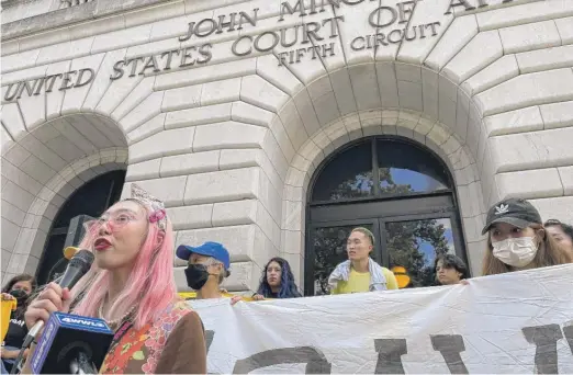 ?? KEVIN MCGILL/AP ?? Woojung “Diana” Park, 22, speaks to demonstrat­ors outside the 5th U.S. Circuit Court of Appeals building in New Orleans on Wednesday.
