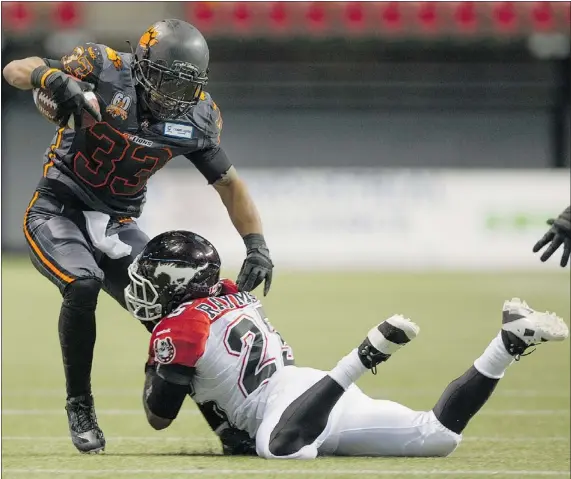  ?? GERRY KAHRMANN/ PNG FILES ?? Calgary Stampeders’ Keon Raymond, bottom, brings down B.C. Lions’ Andrew Harris earlier this year. The Lions’ running game, which is primarily Harris, has been struggling this season while Calgary’s, with Jon Cornish, has been thriving.