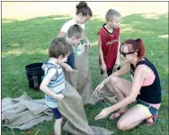  ?? Westside Eagle Observer/MIKE ECKELS ?? Shelia Verser (right) gives a group of youngsters a pep talk before the two-legged sack race which was part of the 65th Annual Decatur Barbecue kids’ games event held at Veterans Park in Decatur Aug. 4.