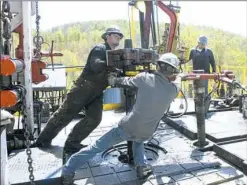  ?? Ralph Wilson/Associated Press ?? Workers move a section of well casing into place at a Chesapeake Energy natural gas well site near Burlington in northeaste­rn Pennsylvan­ia.