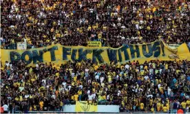  ?? Photograph: Ahmad Gharabli/Getty ?? Beitar Jerusalem La Familia fans hold up a banner before a Uefa play-off against AS Saint-Étienne in 2016.