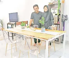  ??  ?? Lokman and his wife Siti Faznur showing the dining table they made. Bernama photo