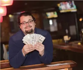  ?? NiCOLAuS CzARnECki / HERALD STAFF ?? ‘THIS BRINGS HOPE’: Corner Tavern server Conor Gallivan holds the $2,021 tip received earlier this week.