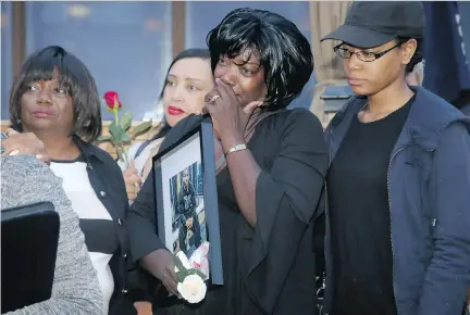  ?? JULIE OLIVER ?? Ashton Dickson’s mother, Donna Dickson, centre, wipes away tears as people speak fondly of her son at a vigil Wednesday outside the Mingle Room bar at 470 Rideau St. Ashton Dickson, 25, was shot dead on June 26 outside the bar following an altercatio­n....