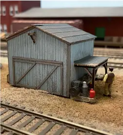  ?? ?? Steve used all three of the sheds in the Bar Mills Shack Pack on the layout. The largest became a machine shed in the yard. Junk piles, a workbench, and a figure carrying a box make it look busy.