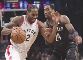  ?? By The Associated Press ?? Toronto Raptors forward Kawhi Leonard (2) drives to the basket against Brooklyn Nets forward Rondae Hollis-Jefferson (24) during first-half NBA action Friday in Brooklyn.