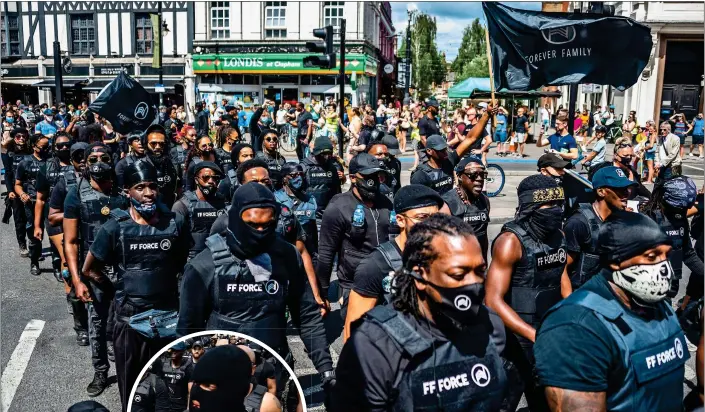  ??  ?? ON THE MARCH: Members of the protest group Forever Family Force heading for Brixton yesterday. Most wore black paramilita­ry-style uniforms including stab vests. Inset left: An activist wearing a full balaclava