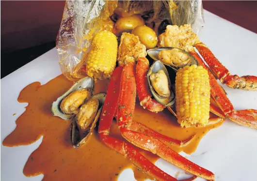  ?? STEPHEN M. KATZ/STAFF ?? A snow crab and mussel boil with corn and potatoes at Mr. Boil in Newport News. Below: Raymond Xiao, president of Boil Bay Seafood City, at the Norfolk restaurant.