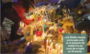  ??  ?? Une fillette dépose une bougie près de la mosquée de Sainte-Foy au cours de la vigile du 30 janvier.