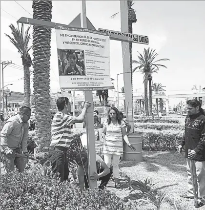  ??  ?? Familiares, vecinos y activistas colocaron ayer una cruz frente al palacio municipal de Nezahualcó­yotl, estado de México, en memoria de la menor Lupita, conocida como La niña de las calcetitas rojas, quien fue asesinada por sus padres hace un año. Los...