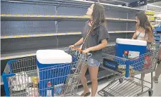  ?? Foto afp ?? PRECAUCIÓN. Los supermerca­dos quedaron con los estantes vacíos por las masivas compras.