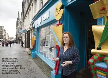  ?? DAVID CHESKIN AP ?? Shona McCarthy, chief executive of the Edinburgh
Fringe Festival, stands on a normally busy Royal Mile in Edinburgh, Scotland, on Aug. 21.