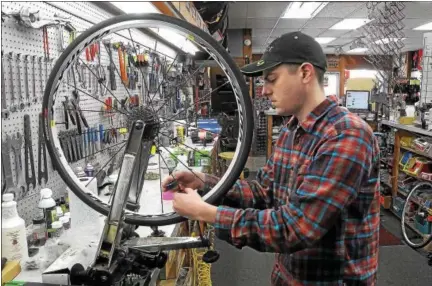  ?? GENE WALSH — DIGITAL FIRST MEDIA ?? Mechanic Ben Landes works on balancing a tire at Scooter’s Bike Shop in Souderton.