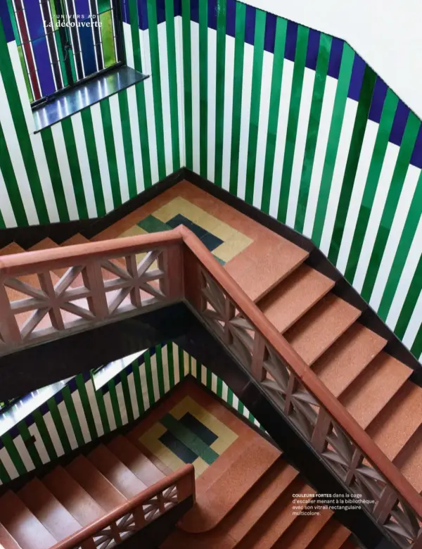  ??  ?? COULEURS FORTES dans la cage d’escalier menant à la bibliothèq­ue, avec son vitrail rectangula­ire multicolor­e.