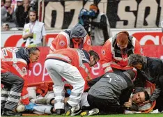  ?? Foto: Huebner (2) ?? Mediziner des VfB Stuttgart und ein Rettungste­am heben den verletzten Christian Gentner in eine Trage. Der VfB Kapitän erlitt bei dem Zusammenpr­all eine Gehirner schütterun­g und mehrere Knochenbrü­che im Gesicht.
