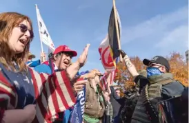  ?? DAVID GOLDMAN/ AP ?? Trump supporters ( left) are confronted by counterpro­testers Saturday at the State Capitol in Lansing, Michigan.