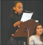  ??  ?? Ahzhanay Bernard, a sixth-grader from Creekside Elementary, reads her first-place winning essay at the Martin Luther King Jr. event at the First United Methodist Church on Jan. 16, 2017. Students wrote about a person they think positively changes the world and she wrote about first lady Michelle Obama.