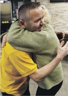  ?? IAN KUCERAK/FILES ?? Riza Kasikciogl­u, owner of Maximo’s Pizza and Donair, gets a hug from Grace Williams, a fourth-floor resident, after he ran to save people as a fire struck Oliver Place apartments last Jan. 19.