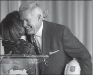  ?? AP/The News & Observer/ROBERT WILLETT ?? (right) hugs University of North Carolina Chancellor Carol Folt after being introduced as the school’s football coach Tuesday in Chapel Hill, N.C. Brown spent 10 seasons at North Carolina before leaving for Texas and later becoming a broadcaste­r.