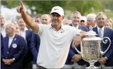  ?? The Associated Press ?? Brooks Koepka celebrates with the Wanamaker trophy after winning the PGA Championsh­ip golf tournament at Oak Hill Country Club on Sunday, in Pittsford, N.Y.