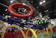  ?? JOHN RAOUX - ASSOCIATED PRESS ?? In this 2019 file photo, attendees try out a roller coaster where the cars spin and turn on display at the Internatio­nal Associatio­n of Amusement Parks and Attraction­s convention in Orlando, Fla.