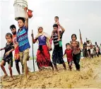  ??  ?? Rohingya refugees walk on the muddy path after crossing the Bangladesh-myanmar border in Teknaf.