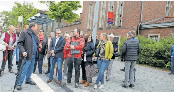  ?? FOTOS: HEIKO LEHMANN ?? Sulzbachs Bürgermeis­ter Michael Adam (CDU, vorne links mit Schirm) erläuterte, was beim Umbau des Bahnhofvor­platzes zu tun war.