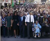  ?? JACQUELYN MARTIN — THE ASSOCIATED PRESS FILE ?? President Barack Obama, center, walks as he holds hands with Amelia Boynton Robinson, who was beaten during “Bloody Sunday,” as the first family and others including Rep. John Lewis, D-Ga., left of Obama, walk across the Edmund Pettus Bridge in Selma, Ala., for the 50th anniversar­y of “Bloody Sunday,” a landmark event of the civil rights movement.