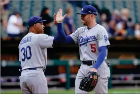  ?? AP PHOTO BY CHARLES REX ARBOGAST ?? Los Angeles Dodgers manager Dave Roberts (30) and first baseman Freddie Freeman celebrate the team’s 11-9 win over the Chicago White Sox in a baseball game Thursday, June 9, 2022, in Chicago.