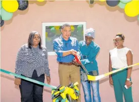  ?? ?? Prime Minister Andrew Holness (second left) and New Social Housing Programme (NSHP) beneficiar­y Patrick Spencer (second right) cut the ribbon to officially hand over a one-bedroom unit in Iron River, West Rural St Andrew. Sharing the moment (from left) are Chair of the Oversight Committee, NSHP, Judith Robb Walters; and Member of Parliament for the constituen­cy, and Minister of State in the Ministry of National Security, Juliet Cuthbert Flynn.