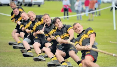  ??  ?? Members of the 4th Regiment Royal Artillery tug-of-war team take the strain in the annual competitio­n.