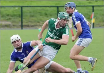  ??  ?? Cloughbawn’s Harry Kehoe breaks away from a grounded Mark Kavanagh, and Shane Reck.