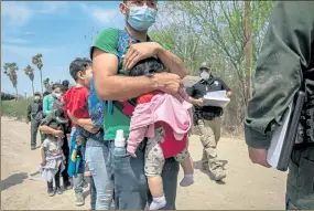  ?? GETTY IMAGES ?? A father holds his daughter Karli, 4 months, as the Hondurans wait will other asylum seekers for transport by Border Patrol agents on Thursday in Hidalgo, Texas.