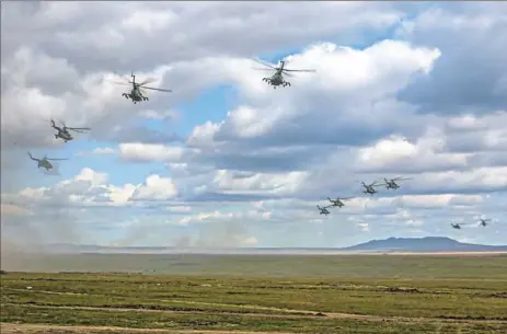  ??  ?? In this photo provided by Russian Defense Ministry Press Service on Tuesday, Russian military helicopter­s fly in Eastern Siberia during the Vostok 2018 war games in Russia. Russia’s military chief of staff says that the military exercises expected to be the biggest in three decades and will involve nearly 300,000 troops.