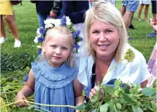  ??  ?? Liv och Josefine Fredriksso­n pyntade midsommars­tången med blommor.