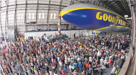  ?? FOTO: PR ?? Brandneu: Etwa 2000 Menschen erleben, wie Ende August 2014 der erste von drei Zeppelinen NT aus Friedrichs­hafen im Goodyear-Hangar in Akron/ Ohio getauft wird. Mit dabei: Friedrichs­hafens OB Andreas Brand und Thomas Brandt, damaliger Chef der ZLT...