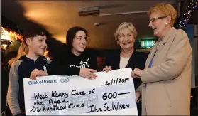  ?? Photo by Declan Malone ?? Tom and Eibhlín O’Connor, who were among the younger members of the Sráid Eoin Wren, presenting a cheque for €600 to Mary O’Donnell and Phil Rohan, representi­ng West Kerry Care of the Aged, at the wren ball night in the Barrack Height on Friday.