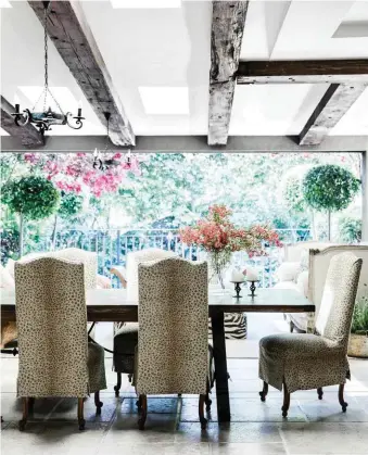  ??  ?? PATIO Marylou loves animal prints left and opposite and slipcovere­d her high-backed dining chairs in Ralph Lauren ‘Leopard Print’ in Sand from Radford. Spanish-style table, Classic Tables. Vase, William Yeoward Crystal. Marylou created the console...