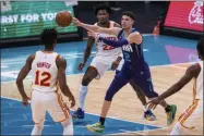  ?? JACOB KUPFERMAN - THE ASSOCIATED PRESS ?? Charlotte Hornets guard LaMelo Ball (2) looks away while passing the ball past Atlanta Hawks forward De’Andre Hunter (12) and forward Cam Reddish (22) during the first half of an NBA basketball game in Charlotte, N.C., Saturday, Jan. 9, 2021.