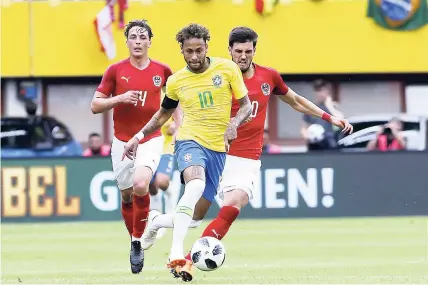  ??  ?? Brazil’s Neymar (centre) dribbles past Austria’s Julian Baumgartli­nger (left) and Austria’s Florian during a friendly match at the Ernst Happel Stadium in Vienna, Austria, yesterday. Brazil won 3-0.