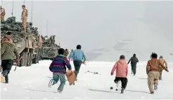  ?? US ARMY ?? Afghan children run to a firing range to collect the expended brass after members of New Zealand Army teams conducted a live-fire exercise in Bamyan Province, Afghanista­n, in 2013.