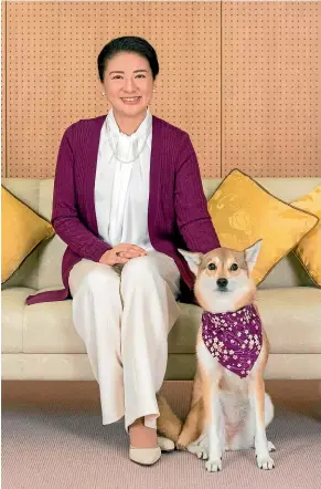  ?? AP ?? Japan’s Crown Princess Masako, wife of Crown Prince Naruhito, poses with her pet dog, Yuri, for a photo at her residence Togu Palace in Tokyo. Masako celebrated her 55th birthday on Sunday.