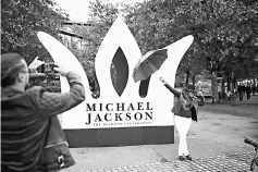  ??  ?? A fan has her photograph taken next to aGiant Crown installed to celebrate the diamond birthday of Michael Jackson, on the South Bank in London, Britain Aug 29, 2018. — Reuters file photo
