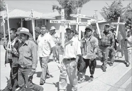  ?? Jocelyn Sherman
Associated Press ?? FARMWORKER­S carry crosses bearing the names of California field laborers who died from the heat during a march in June 2008.