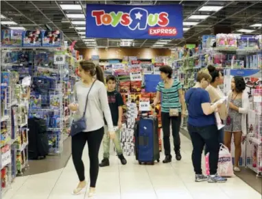  ?? ALAN DIAZ — THE ASSOCIATED PRESS FILE ?? In this Friday file photo, shoppers browse at a Toys R Us store in Miami. The toys your kids unwrap this Christmas could invite hackers into your home. That Grinch-like warning comes from the FBI, which said this summer that toys connected to the...